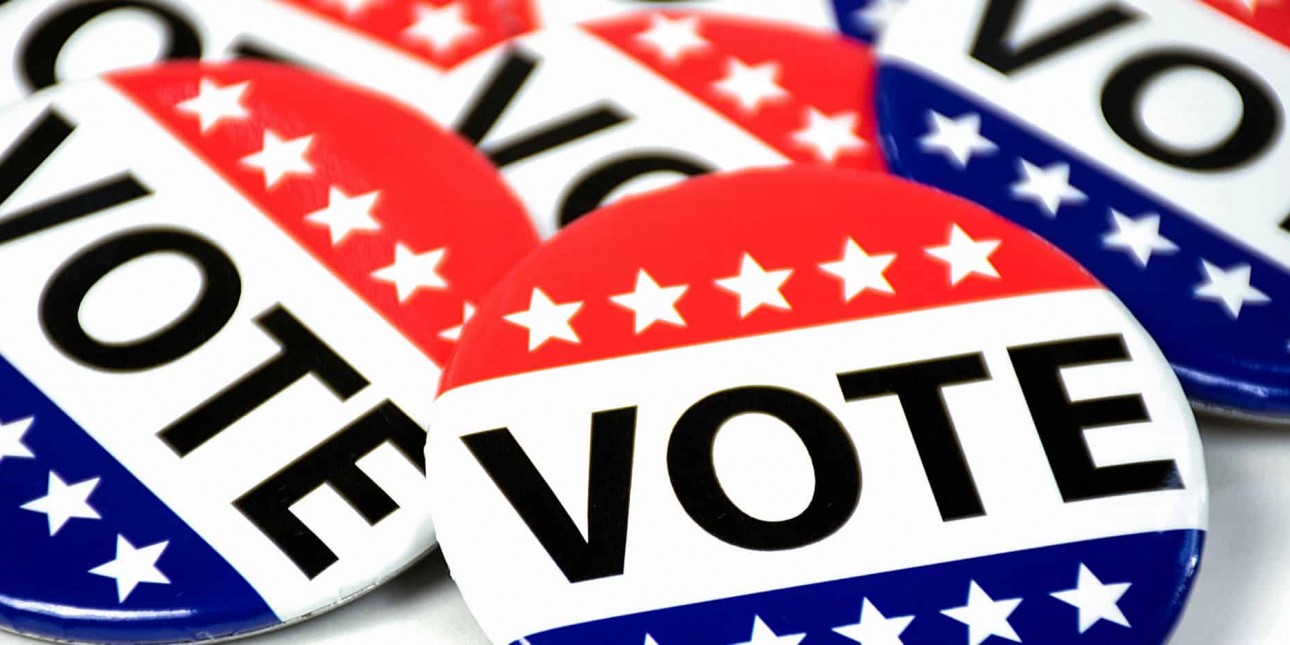 Pile of red, white, and blue Vote buttons