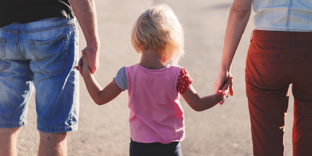 child holding their parents' hands