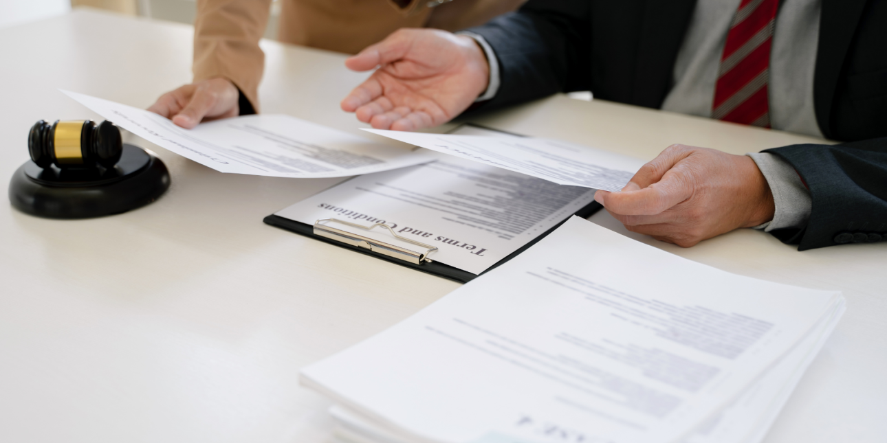 Two people reviewing documents on a table next to a gavel