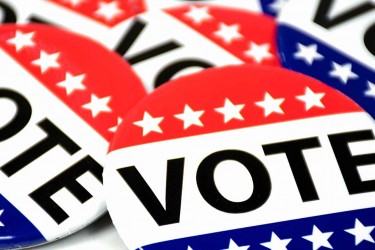 Pile of red, white, and blue Vote buttons