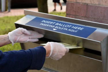 Person inserting a ballot into a drop box